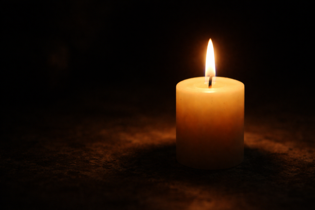 Candela accesa in ambiente oscuro con zone di luce progressive, immagine metaforica del processo della psicoterapia psicodinamica che rende visibili livelli profondi dell’esperienza interiore.